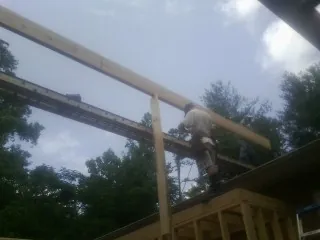 Carpenter setting a ridge beam over a new addition frame — Ice Dam Removal by Roofing Brothers in Gwynedd Valley