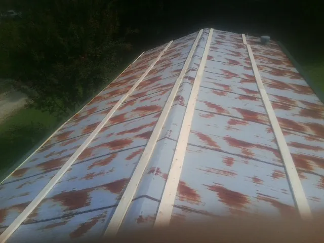 Rusted metal roof panels with new wood purlins before replacement — Storm Damage Roof Repair in Gwynedd Valley by Roofing Brothers