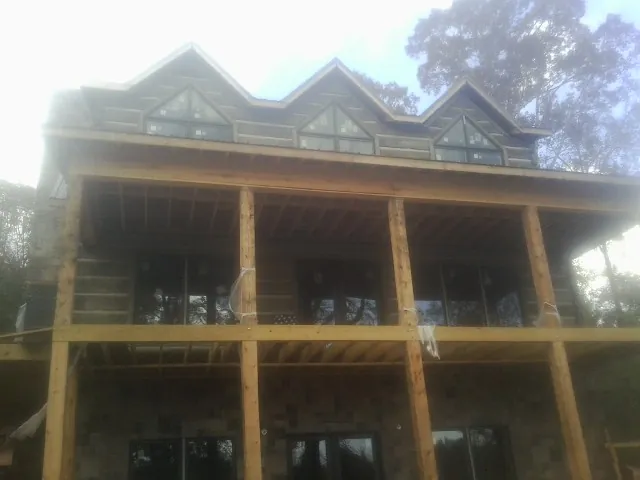 Dormers and porch framing on a large log home under construction — Roof Coating work by our crew in Gwynedd Valley