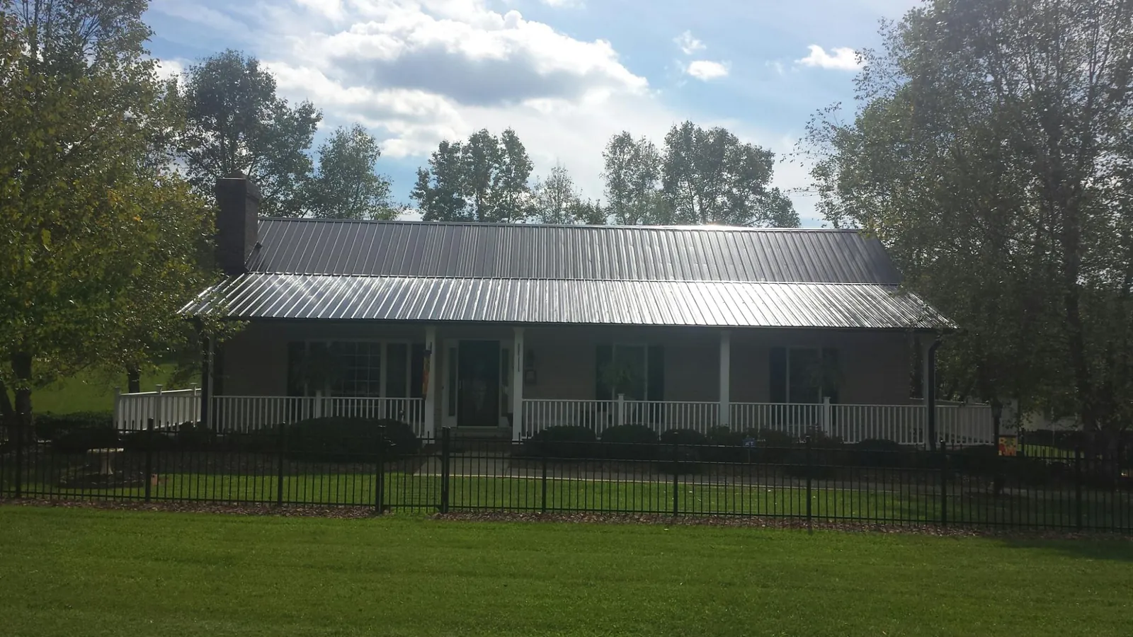 Gray metal roof on a brick ranch with a full width front porch — Gutter Guard Installation work by our crew in Gwynedd Valley