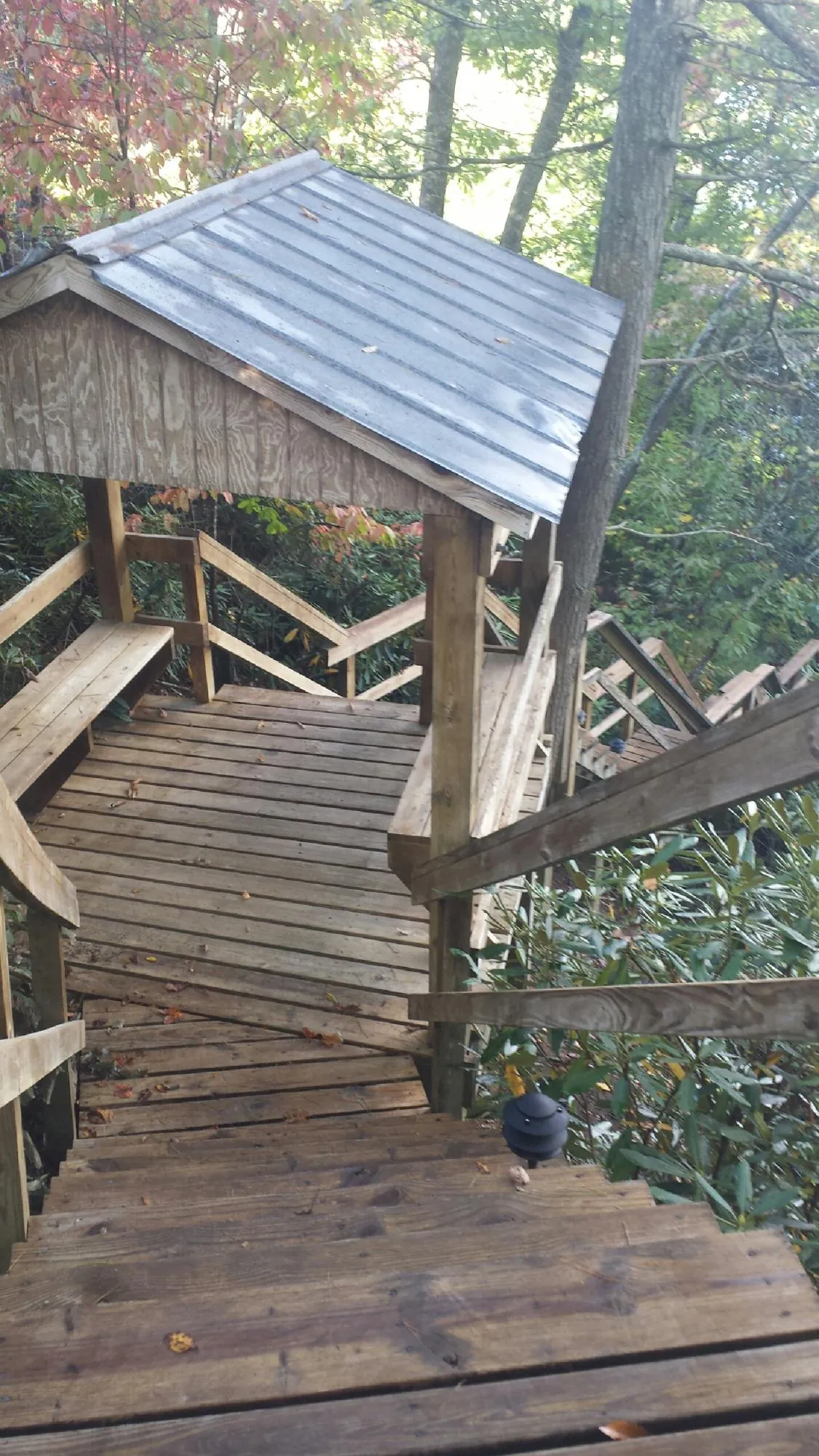 Metal roofed shelter over wooden steps on a wooded walkway — Skylight Repair & Installation work by our crew in Gwynedd Valley