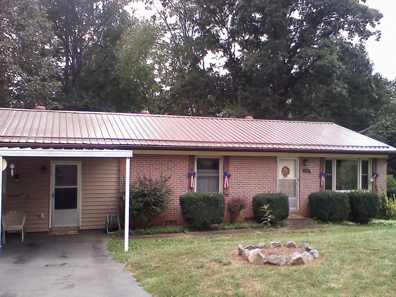 Bronze metal roof and carport on a brick ranch home — Roof Repair work by our crew in Gwynedd Valley